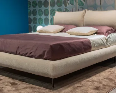 Letto in tessuto con testiera impreziosita da elementi laterali in metallo che esaltano il bordo della testiera su cui poggiano gli ampi cuscini imbottiti Harald di Novaluna